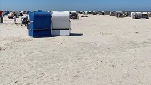 A beach with several beach tents and a clear sky. - Vacation cottage Mittelweg 41a (Wittmund)