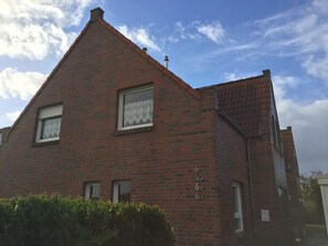 A red brick building with three windows and a small porch.