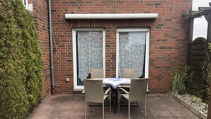 A brick house with a patio area featuring a table and chairs.