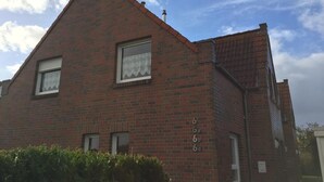 A red brick building with three windows and a small porch.