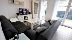 A modern living room with a sofa set, a TV, and a small table with candles.