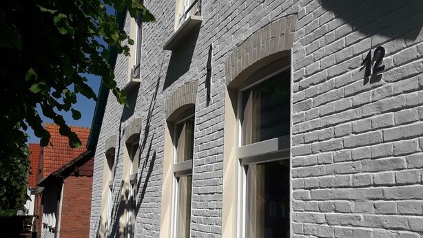 A building with a brick facade, multiple windows, and a visible number '12' on the right side. - Vacation home Mühlenstraße 12 Nr. 1 - Holiday home Mühlenstraße 12 Nr. 1 in (Wittmund)