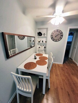 Enjoy meals in this dining area with a round table, matching chairs, and a large mirror above.