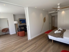 Una camera d'albergo moderna con un letto, una scrivania, una sedia, una lampada e un quadro appeso al muro.