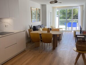 A modern living room with a dining area, large windows, and a view of the outdoors.