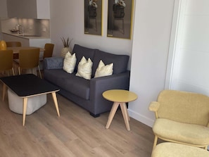 A modern living room with a sofa, a coffee table, and two chairs.