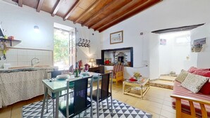 A cozy kitchen with a dining area, a sofa, and a TV.