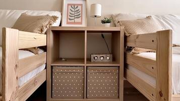 Un lit superposé en bois avec une petite armoire en bois au milieu.