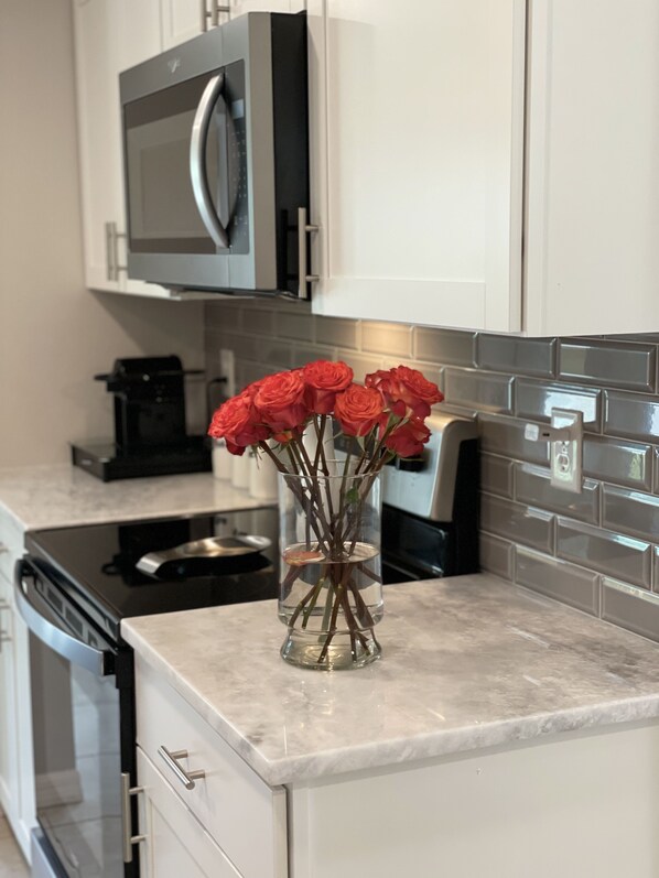A kitchen with white cabinets, a microwave, and a coffee maker. - Fully renovated house with very clean design. New Kitchen and bathrooms. (Venice)