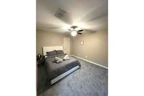 Cozy retreat with a single bed, ceiling fan, and light fixture.