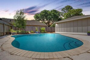 Enjoy a refreshing dip in the pool surrounded by a deck and lush surroundings.