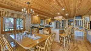 Un interior de madera con comedor, cocina y escalera.