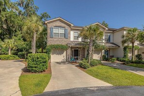 A two-story house with a brick facade, a front garage, and a well-maintained lawn. - Minutes away from restaurants and activities and c (Saint Simons Island)
