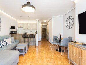 A modern apartment with a kitchen, dining area, and living room.
