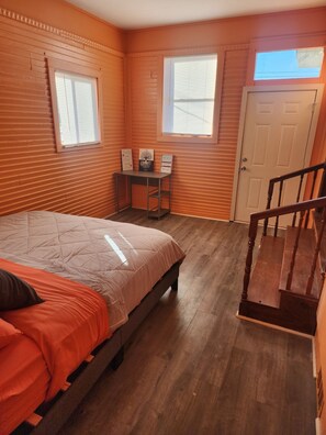 Une chambre à coucher avec un lit, un bureau et une porte.