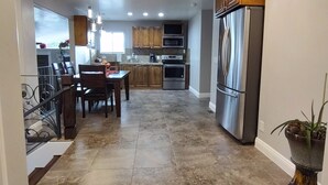 A spacious kitchen with a central island, stainless steel appliances, and a dining area with a chandelier. - The Queen's Respite (A) 2 bedrooms, 2 bathrooms (Toquerville)