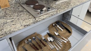 A kitchen with a granite countertop, a microwave, and a drawer with utensils. - Departamento a una cuadra de la playa by Gpsrentas (Mazatlán)