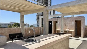 A rooftop terrace with a sink, bar stools, and a canopy. - Departamento a una cuadra de la playa by Gpsrentas (Mazatlán)