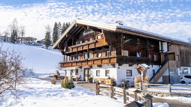 Una cabaña de madera con balcón, rodeada de nieve.
