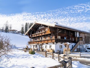 A wooden chalet with a balcony, surrounded by snow.
