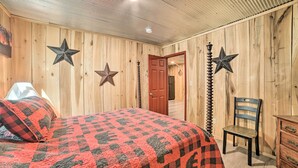 Ein Zimmer mit Holzwänden, einem Bett, einem Sessel und dekorativen Sternen an der Wand.
