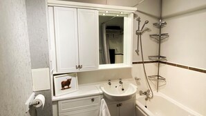 Une salle de bain avec des toilettes, un lavabo et une baignoire.