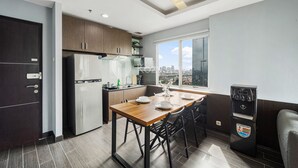 A modern kitchen with a dining area, a refrigerator, a coffee machine, and a water dispenser. - PECAN by Kozystay (Jakarta)