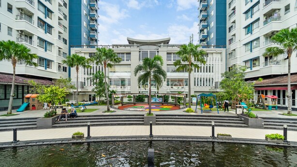 A modern hotel with a central courtyard, palm trees, and a water feature. - PECAN by Kozystay (Jakarta)