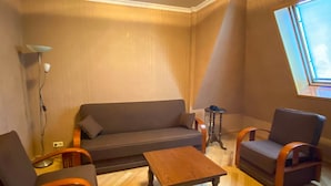 A living room with a sofa, two armchairs, a coffee table, a floor lamp, and a small side table. - Batesta Hotel (Tbilisi)