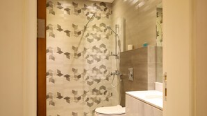 A modern bathroom with a shower, toilet, and vanity. - Tura Residence Qurtuba (Riyadh)