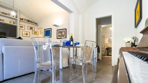 Una sala de estar moderna con comedor, un piano y una estantería.