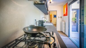 Una cocina moderna con estufa a gas, una sartén y un lavamanos.