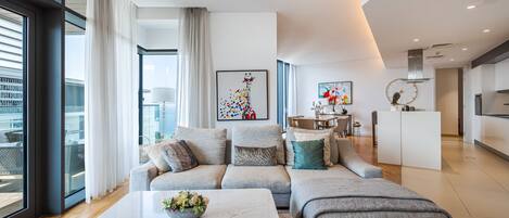 A modern living room with a sofa, a coffee table, and a dining area.