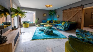A modern living room with a large window, a blue sofa set, a wooden coffee table, and a green armchair. - 5 Bedroom Villa in Mendig (Mendig)