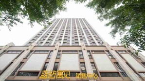 A tall building with multiple floors and a prominent sign in the center. - Feilisi Apartment (Zhongshan Yuelai South Road) (Zhongshan)