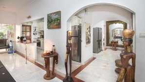 A spacious kitchen with modern appliances, a dining area with a large mirror, and unique wooden sculptures. - Exclusive Villa, 6 Bedrooms, Private Pool, Garden View, 10 Mins LK Metro (Pattaya)