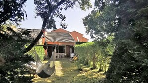 A house with a tiled roof, a hammock, and a small patio area. - 10 MNS from PORTO VECCHIO MINI VILLA WITH SEASIDE LAND MER-6 People (Saint Lucie de Porto Vecchio)