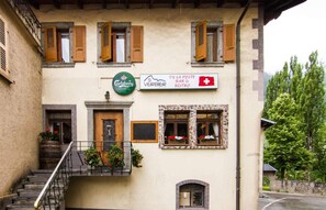Un edificio con un cartello che pubblicizza Carlsberg, un bar e bistrot di Verbier e una bandiera svizzera.