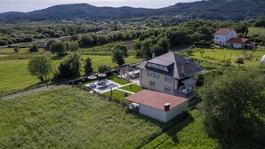 Une grande maison avec un vaste jardin, une piscine et une pelouse bien entretenue.