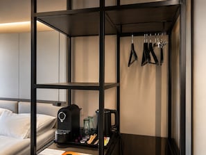 A hotel room with a bed, a coffee machine, a tray with cups and condiments, and a hanging rack with keys. - Wabi Hotel - Beauty & Dental Center (Sopron)