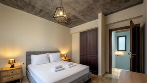 Une chambre à coucher comprenant un lit, des lampes de chevet, une armoire et une porte donnant sur une autre pièce.