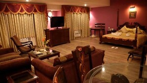A hotel room with a bed, a TV, a desk, and a chair. - HOTEL ANS INTERNATIONAL (Raigarh)