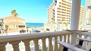 A balcony with a view of the ocean, a building with a tiled roof, and palm trees. - OceanView,3500sqft,60sec Beach Access! 4 bedrooms with 4 ensuite baths&Elevator! (South Padre Island)