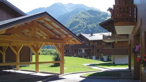 Un bâtiment en bois doté d’un patio couvert et offrant une vue sur une montagne.