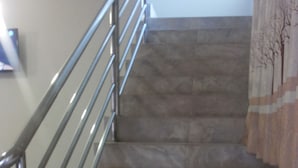 A staircase with metal railings and a patterned carpet. - DAKS HOTEL KIRINYA (Kampala)