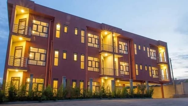 A multi-story building with balconies and illuminated windows, suggesting a residential or hotel structure. - DAKS HOTEL KIRINYA (Kampala)