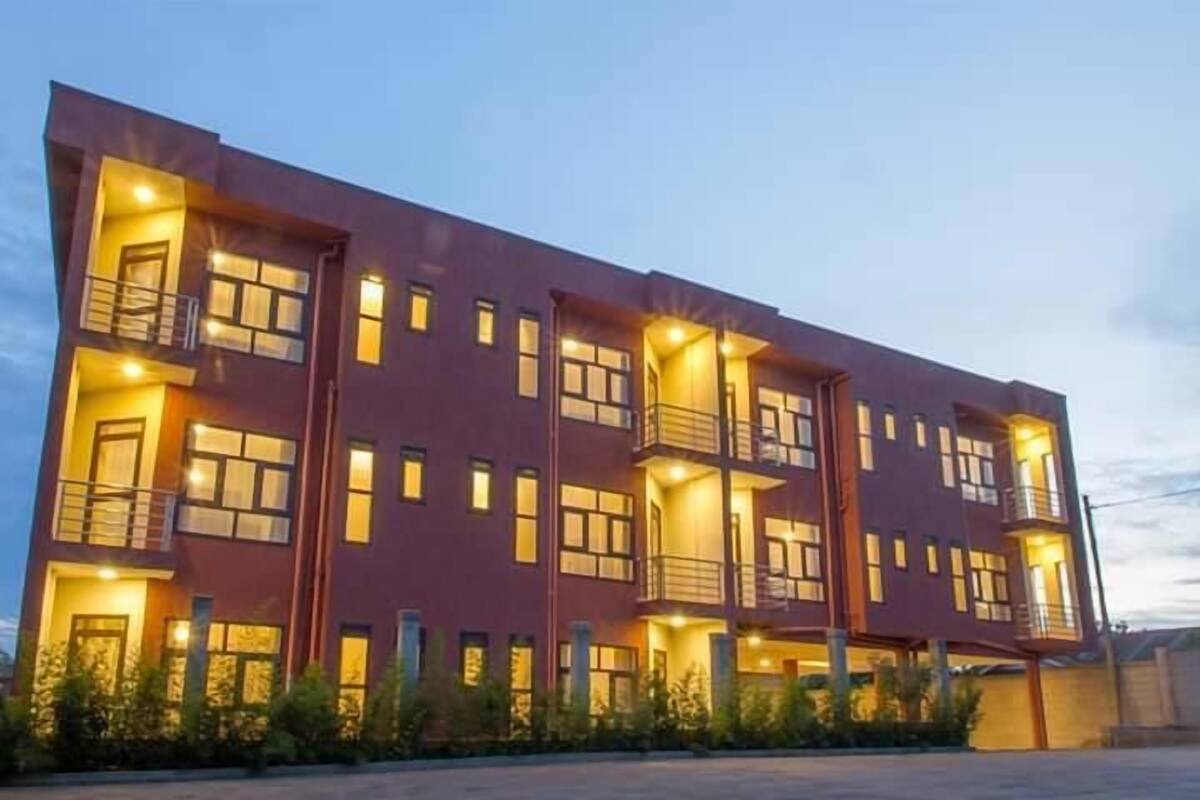 A multi-story building with balconies and illuminated windows, suggesting a residential or hotel structure.