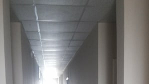 A long, narrow hallway with tiled flooring and white walls. - DAKS HOTEL KIRINYA (Kampala)