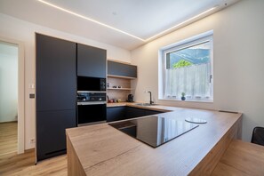 Eine moderne Küche mit Kochinsel, eingebauten Geräten und einem Fenster mit Ausblick.
