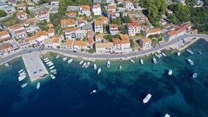 Vista aérea de una ciudad costera con edificios, un puerto deportivo y barcos.